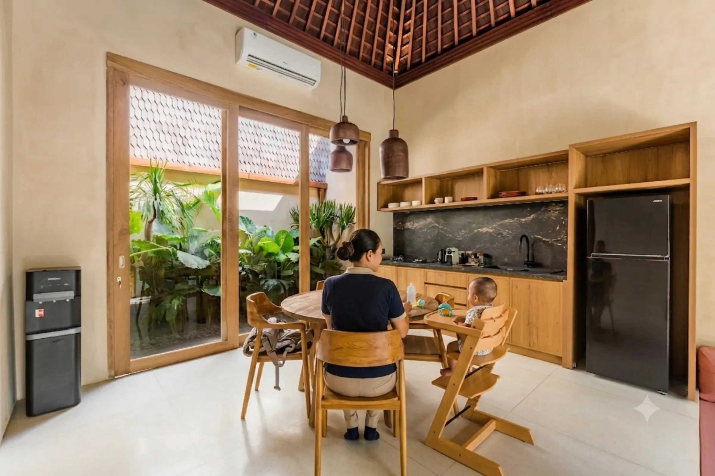 Nanny feeding a toddler at the villa breakfast table