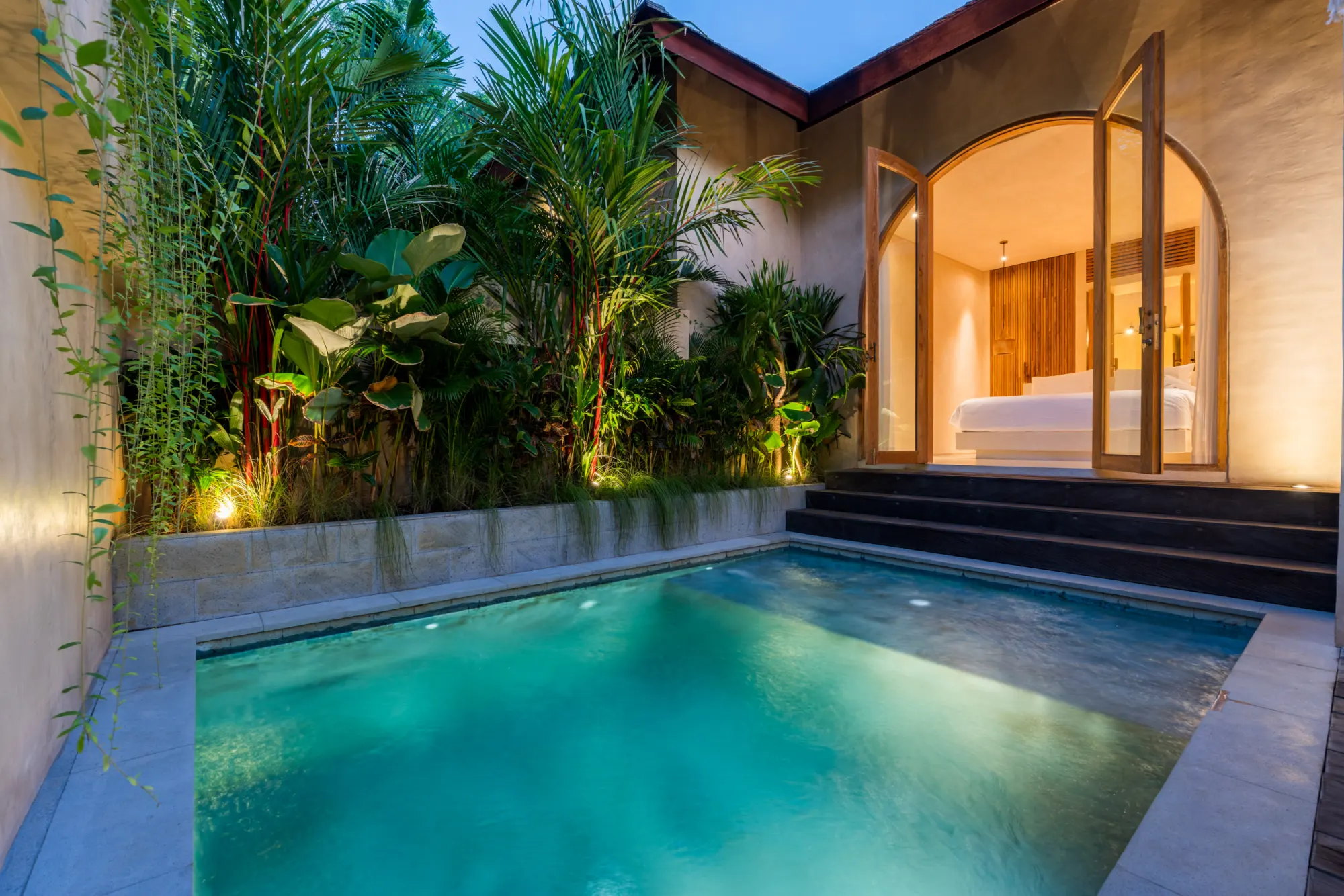 Dusk exterior with striped umbrella and lounge chairs by water