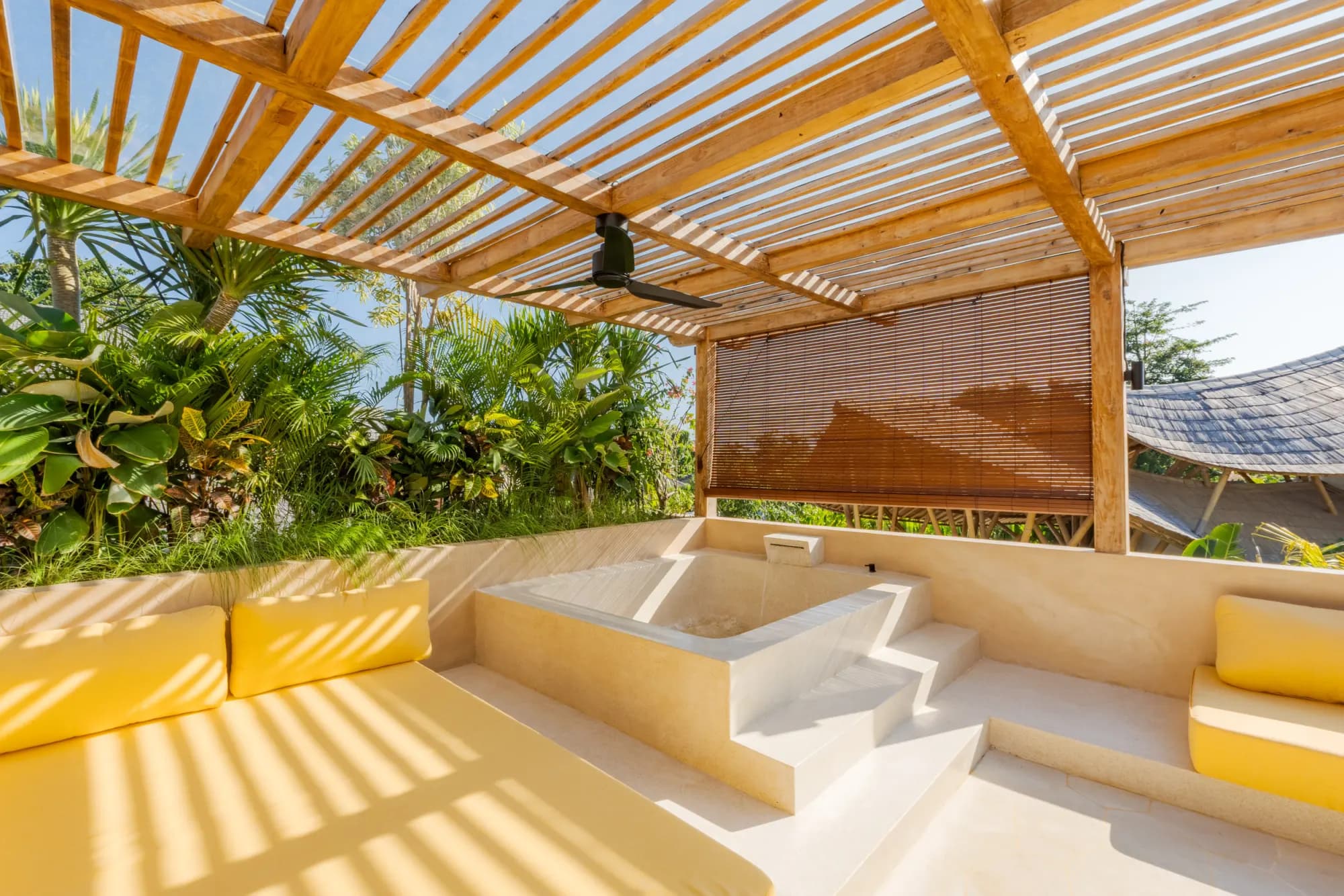 Front terrace with yellow bench seating and wooden doors