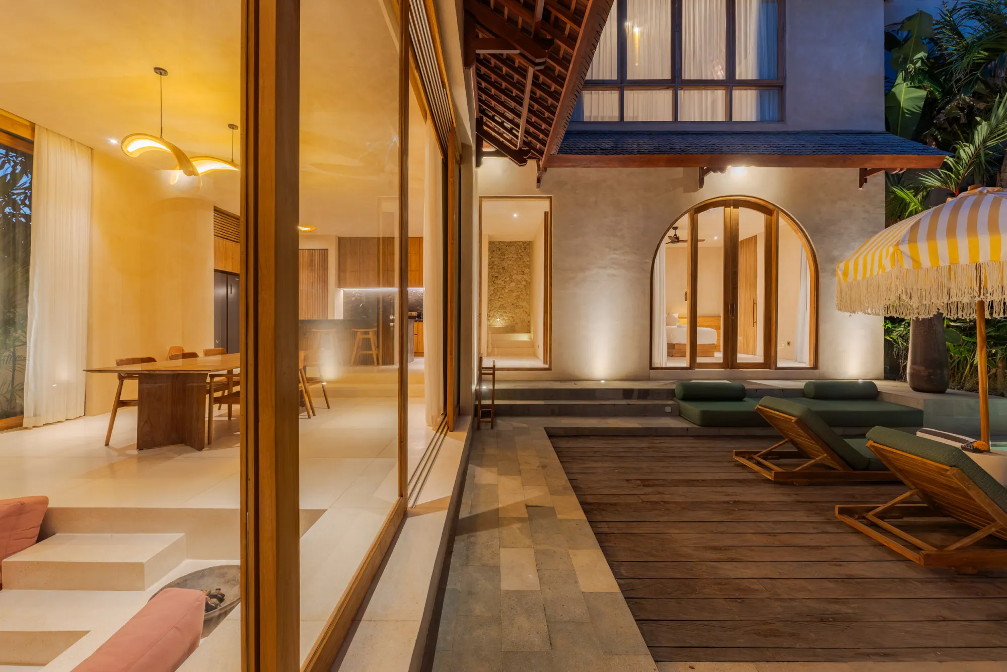 Evening interior view showing lit terrace with pool access