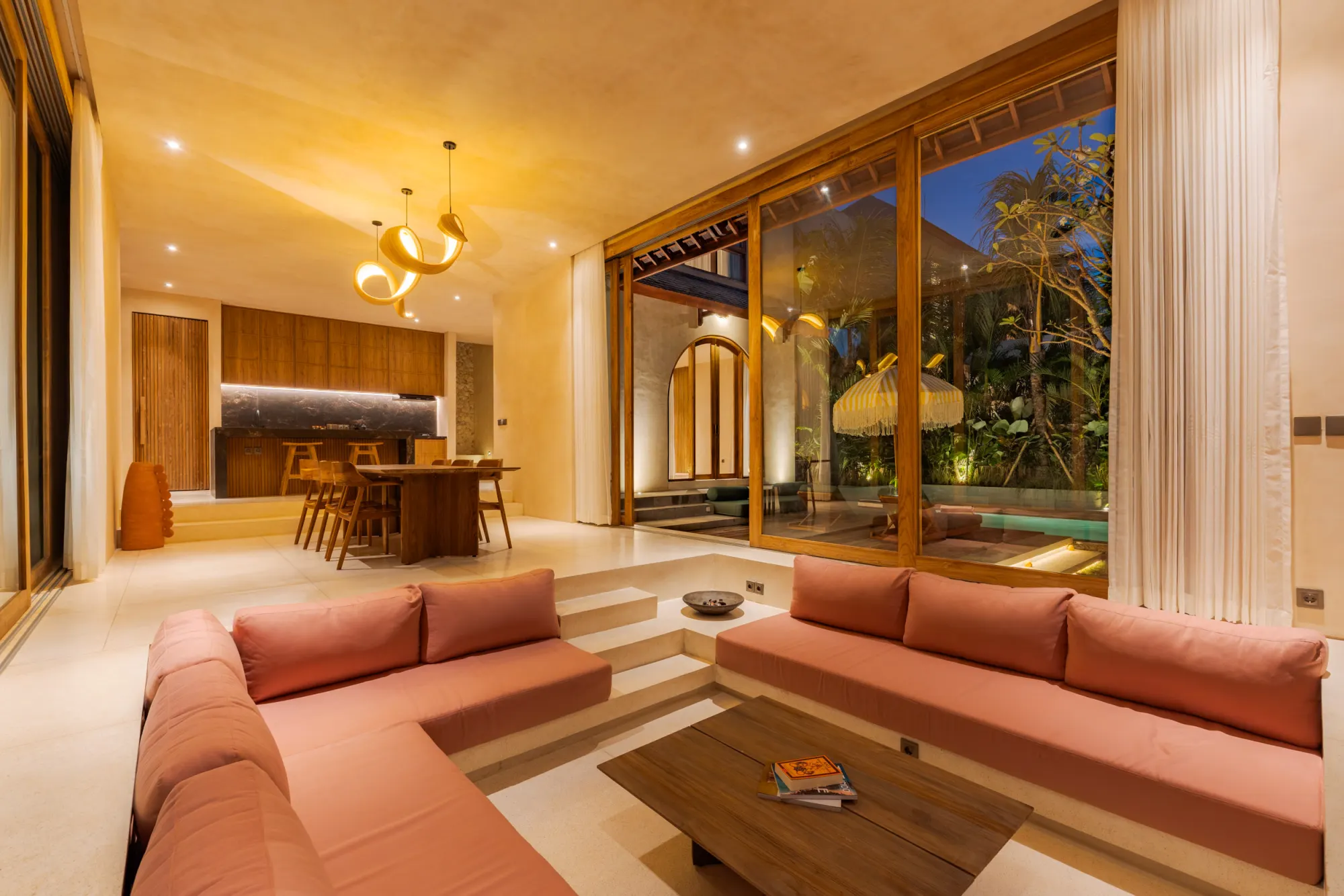 Nighttime pool scene with loungers and illuminated pergola