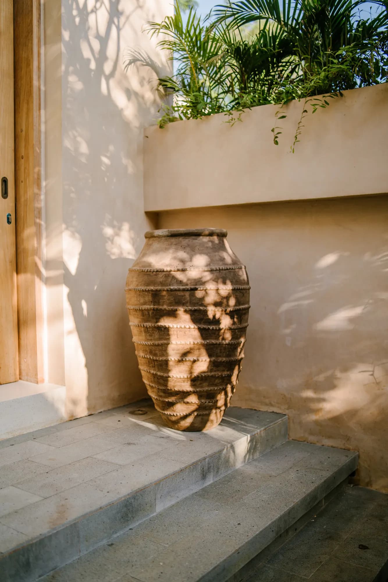Sculptural basket with tropical planter in outdoor courtyard setting