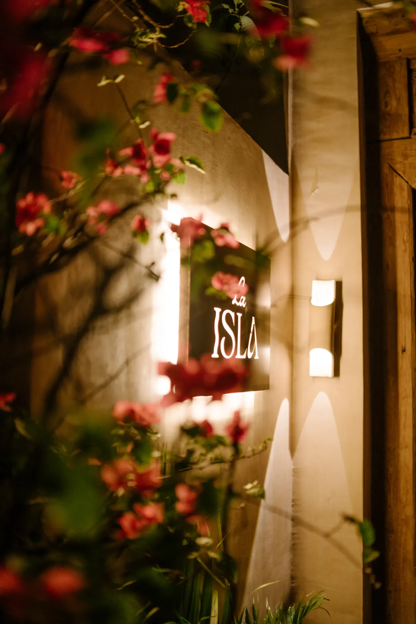 "La ISLA" sign framed by bougainvillea flowers