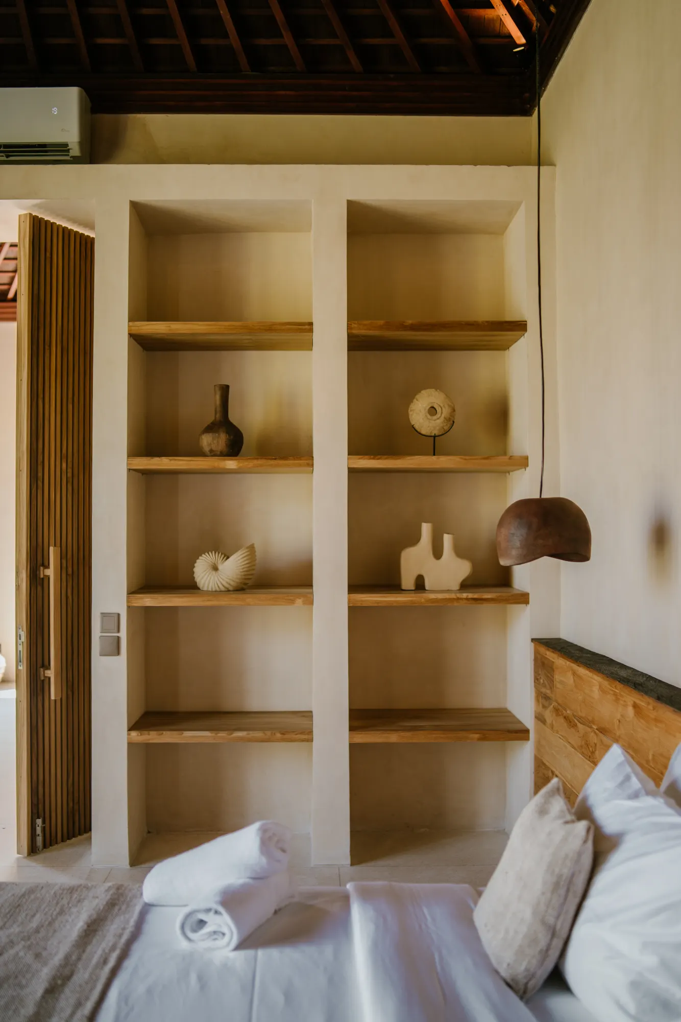 Bedroom with open shelving displaying decorative objects