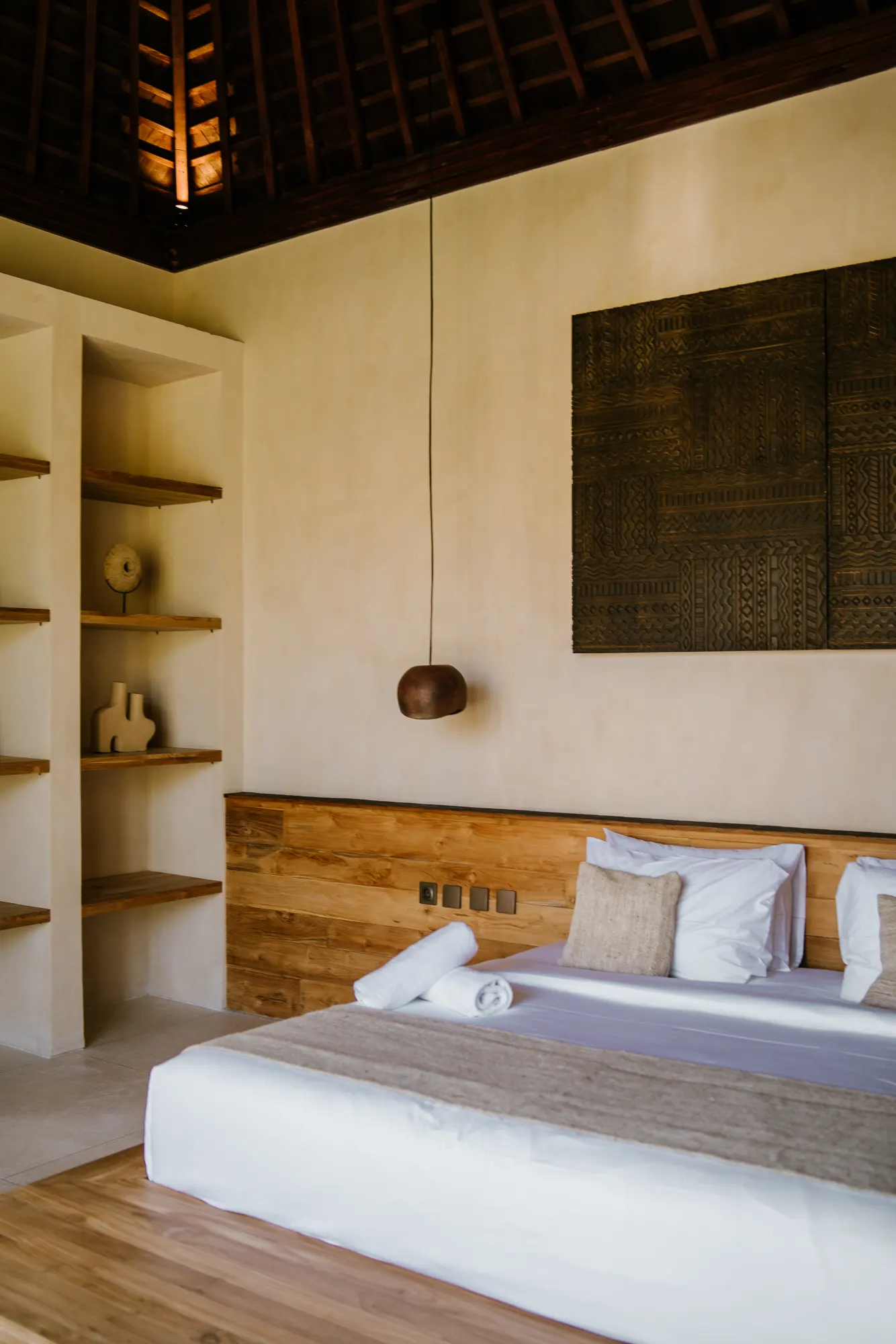 Spacious bedroom interior with high ceiling and art