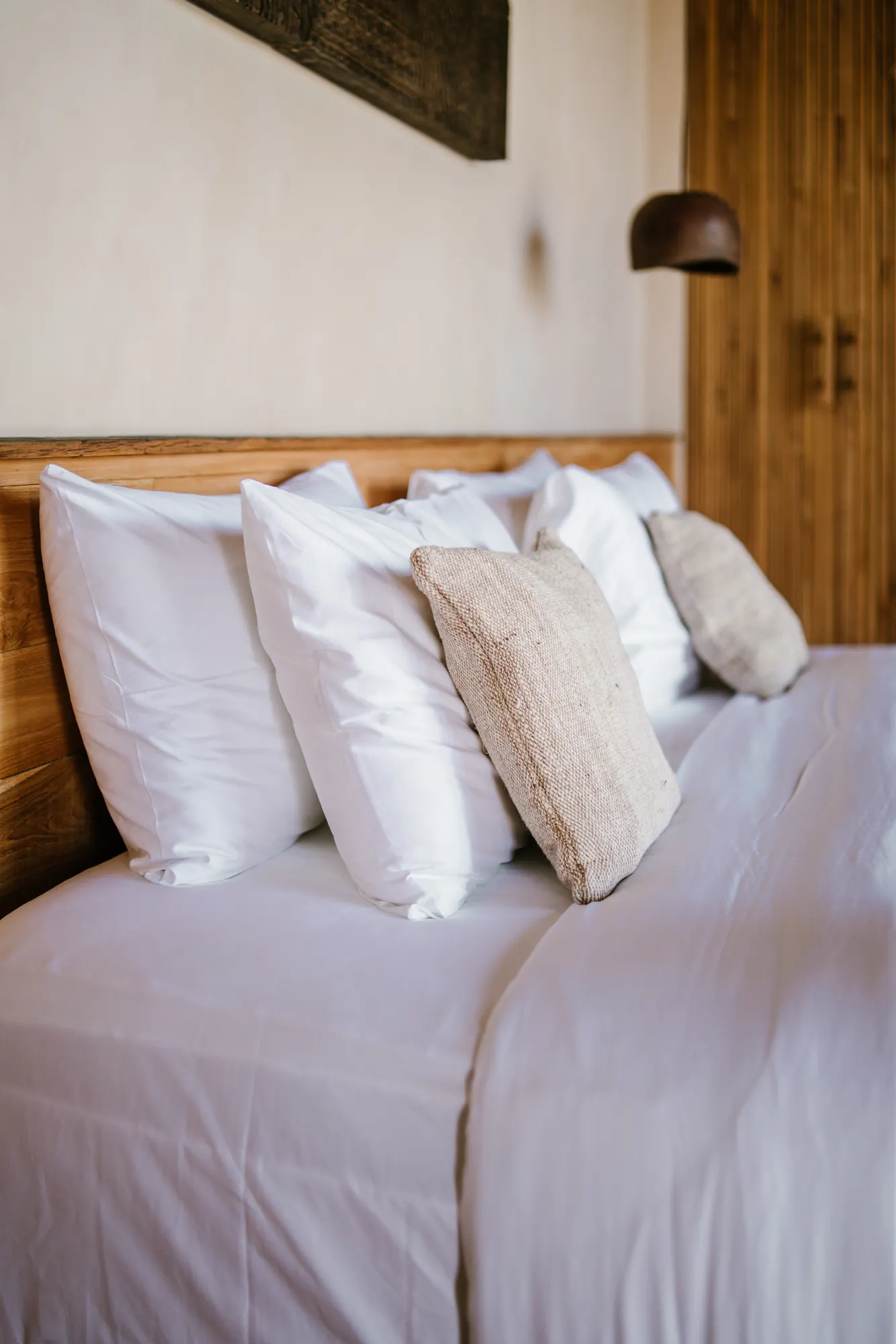 Close-up of bedroom pillows and wooden headboard