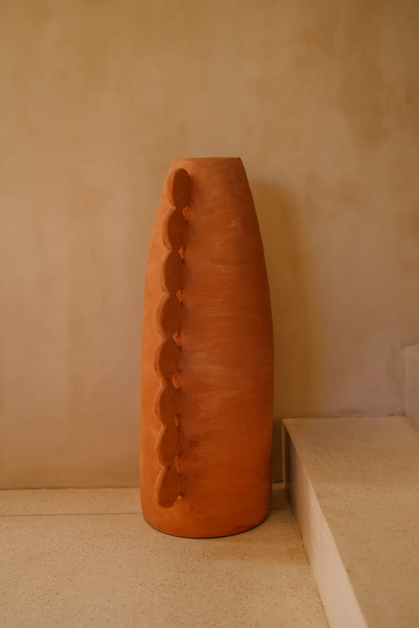 Clay sculptural vessel in minimalist interior space