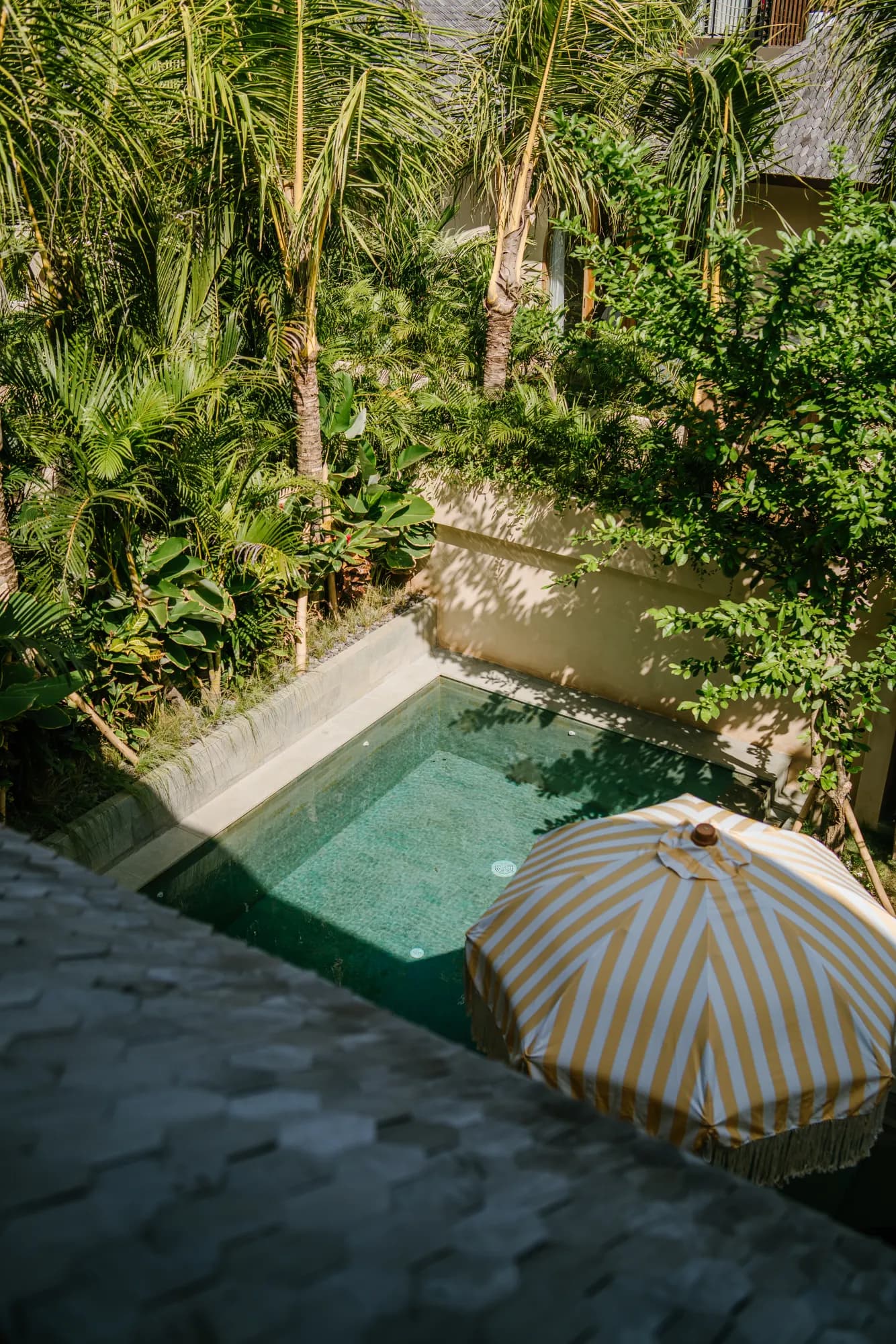 Aerial view of courtyard with striped umbrella and pool