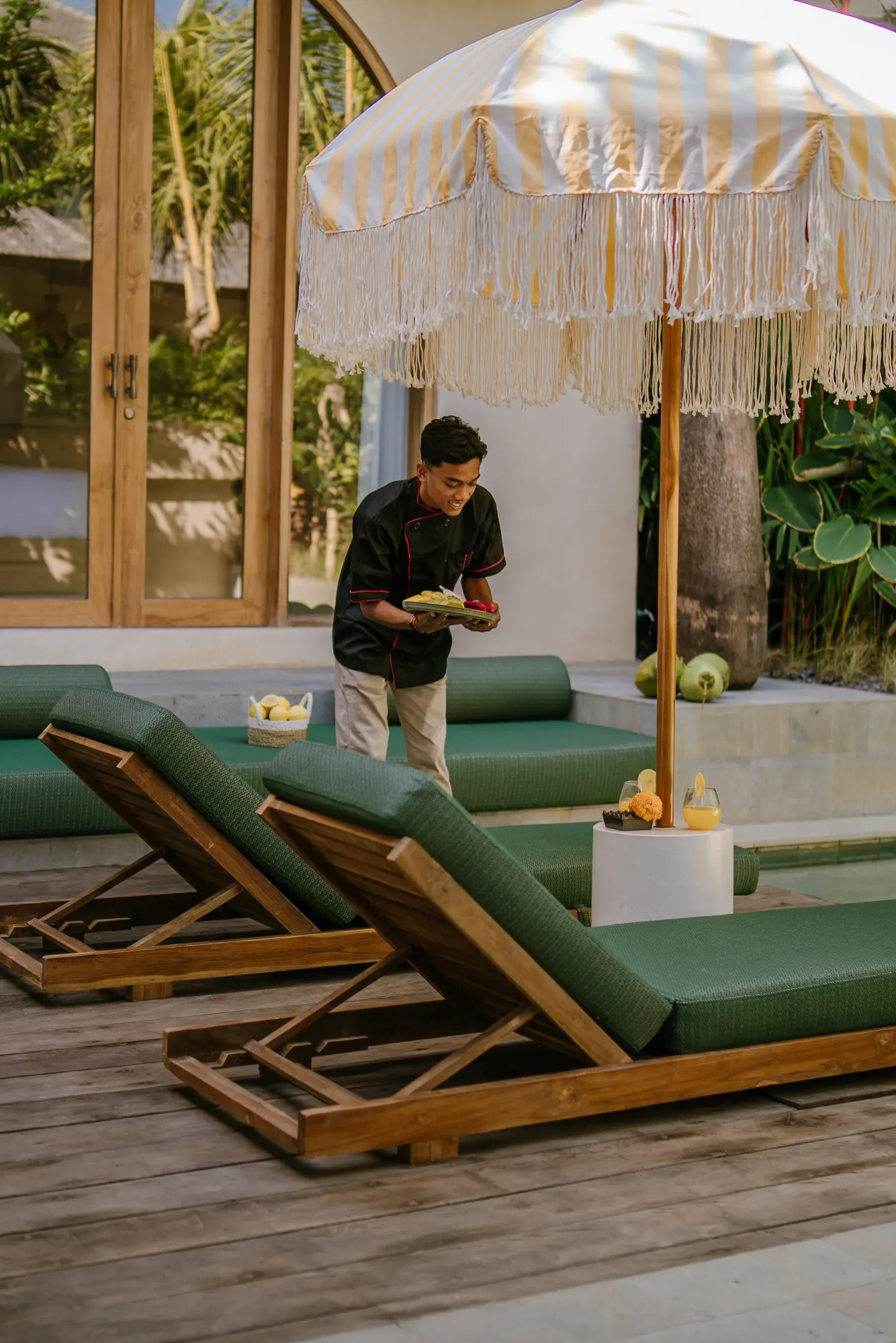 Sunny terrace with loungers and striped umbrella shade